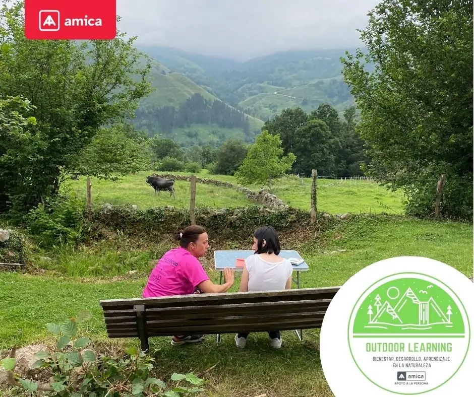 Dos personas sentadas en un banco en plena naturaleza dentro del programa outdoor learning